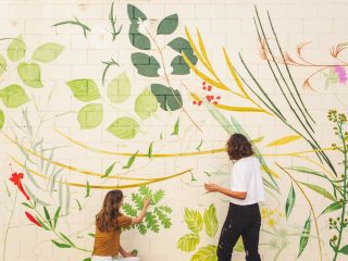 two women working on a mural painting at the piccolo