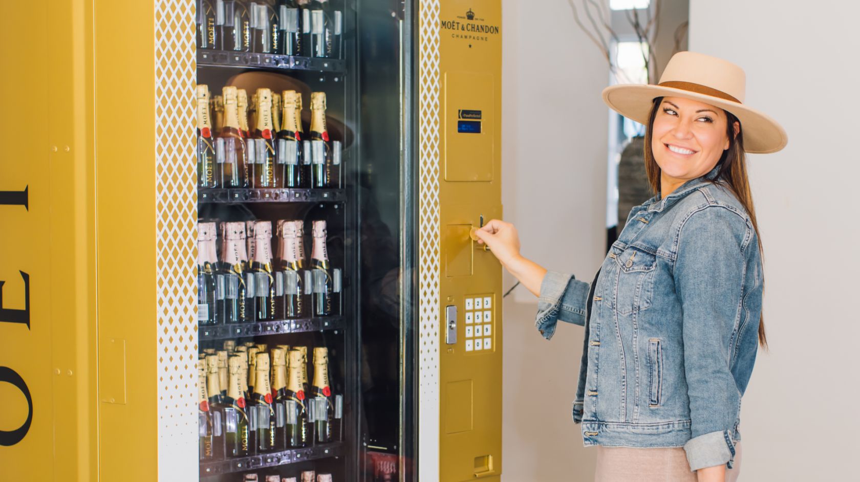 A Person Wearing A Hat And Standing Next To A Vending Machine